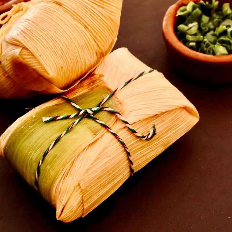 Tamales envueltos en hoja de chala atados con hilo